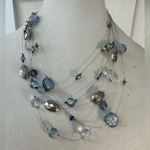 Two blue silvertone infinity style necklaces